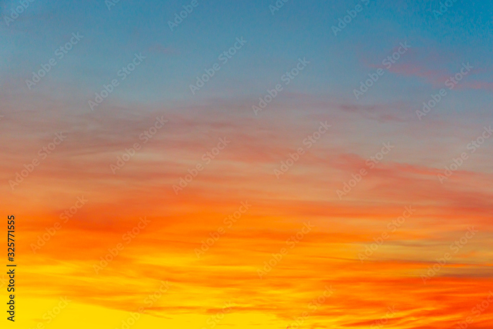 Bright orange and yellow colors sunset sky. Yellow blue sunrise sky with sunlight