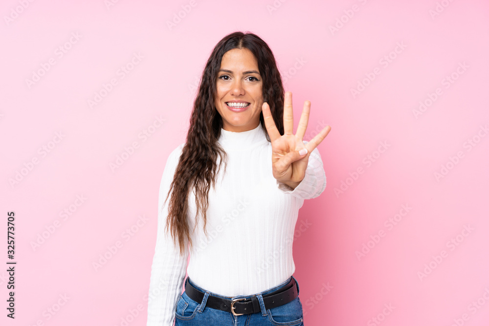 Young woman over isolated pink background happy and counting four with fingers Young woman over isolated pink background happy and counting four with fingers