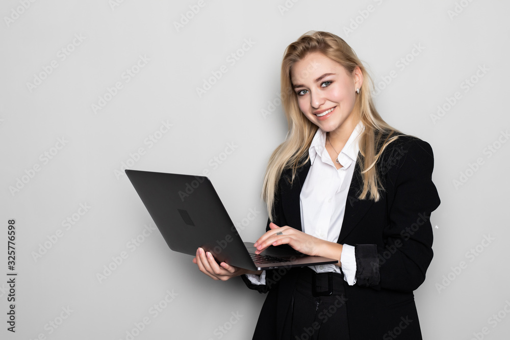 Successful business woman with laptop is standing on isolated white background. Successful business woman with laptop is standing on isolated white background.