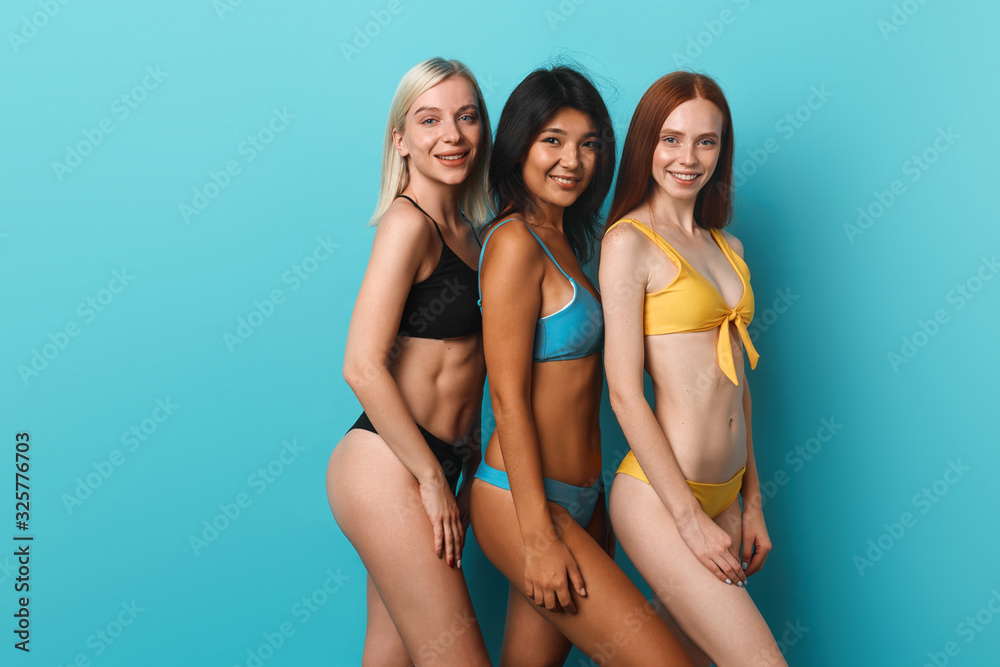 sexy slim girls going to swim in the swimming pool. close up photo, isolated blue blue background. copy space youth, resort,weekend, day off - obrazy, fototapety, plakaty 