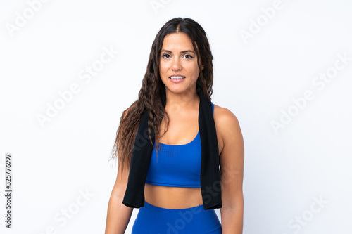Young sport woman over isolated white background with sport towel © luismolinero