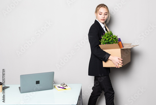 Foto Waist up portrait of happy young businesswoman holding box of personal belonging