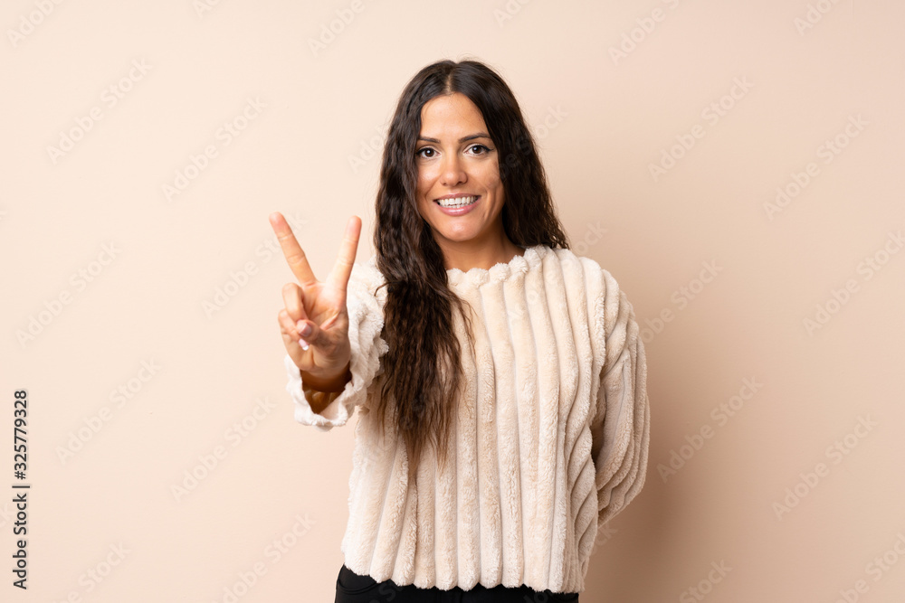 Young woman over isolated background smiling and showing victory sign