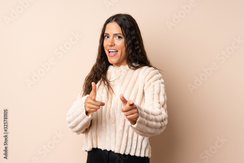 Young woman over isolated background pointing to the front and smiling