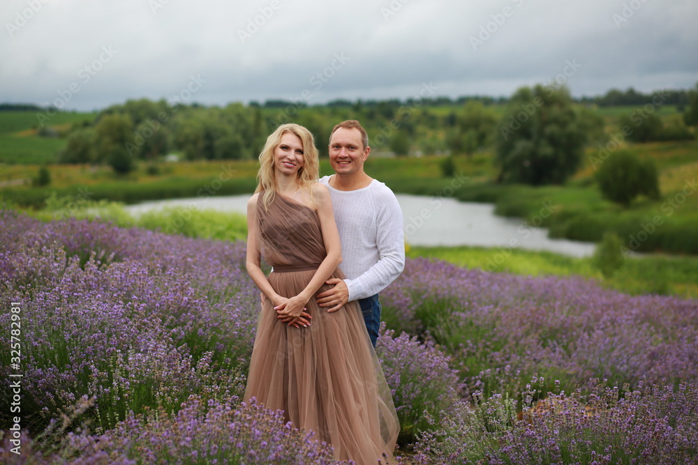  happy couple cuddling, having fun and relaxing in a lavender field in summer