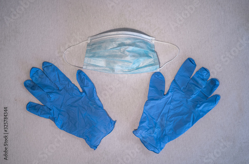 Blue surgical mask and gloves background. Medicine, healthcare and dentistry. Infection and spread protection and prevention. Coronavirus COVID-19 outbreak.