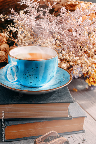 Fotografija tea and a book in the spring sunshine. near honey and flowers