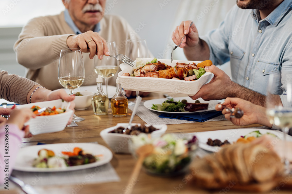 Close-up of multi-generation family eating lunch at dining table.