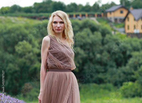  blonde girl in lavender field in summer enjoying vacation