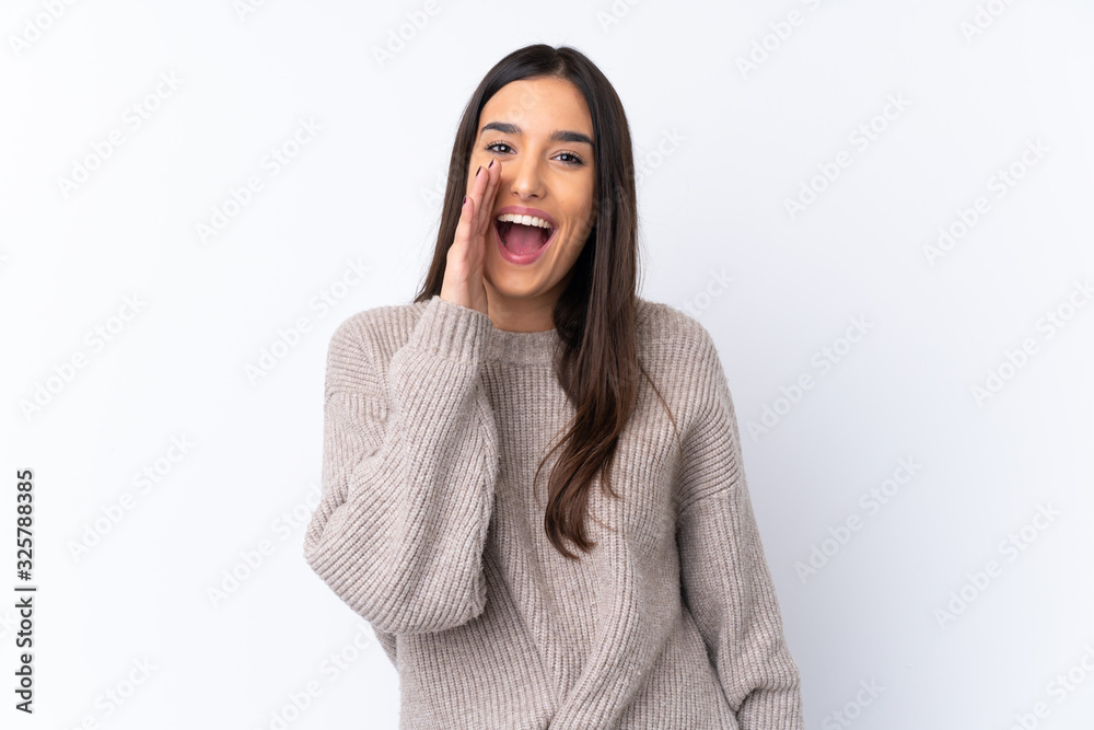 Young brunette woman over isolated white background shouting with mouth wide open Young brunette woman over isolated white background shouting with mouth wide open