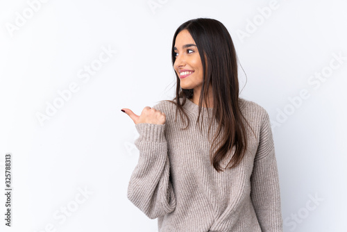 Young brunette woman over isolated white background pointing to the side to present a product