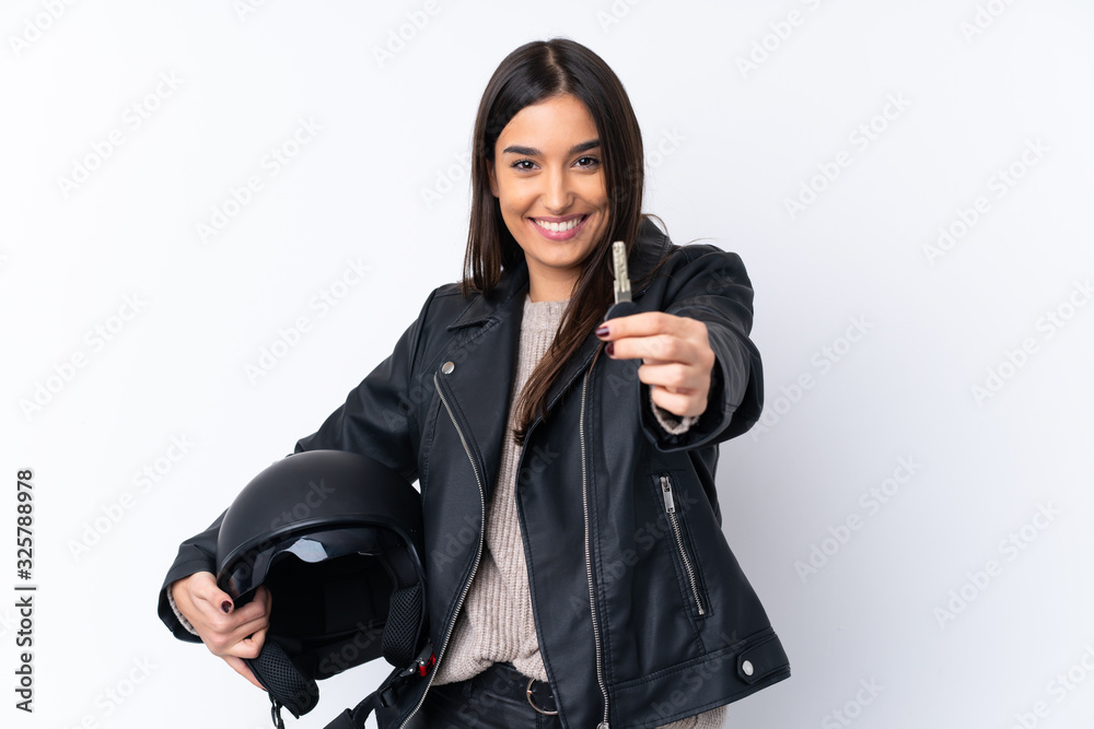 Young brunette woman with a motorcycle helmet and holding a key over isolated white background Young brunette woman with a motorcycle helmet and holding a key over isolated white background