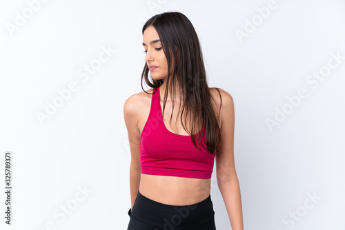 Young sport brunette woman over isolated white background stretching leg