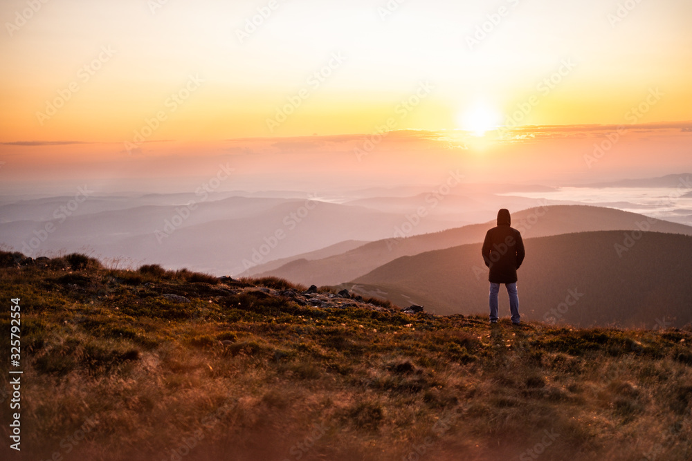 silhouette of man in mountains at sunset
