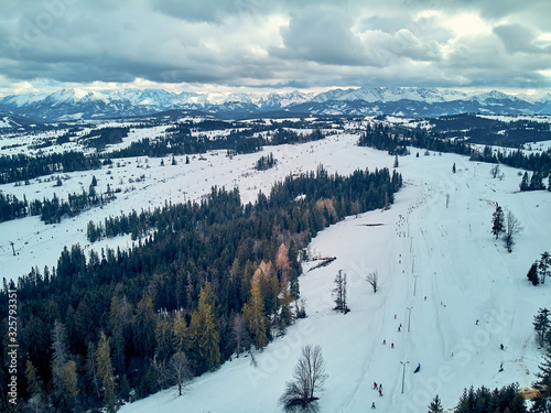 Beautiful panoramic aerial drone view to the ski slopes with lifts in the Bialka Tatrzanska ski resort Tatra Mountains (Tatras, Tatra) - mountain range between Slovakia and Poland