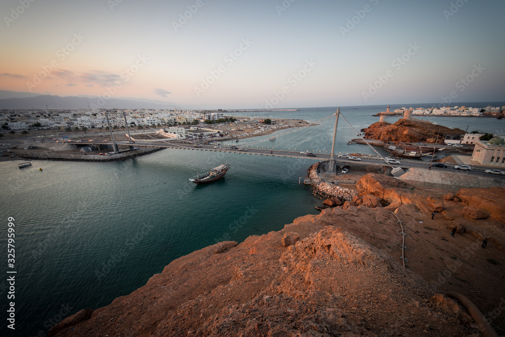 Boat crossing the suspension bridge during at Sur's bay, Oman