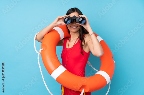 Tableau sur toile Lifeguard woman over isolated blue background with lifeguard equipment and with