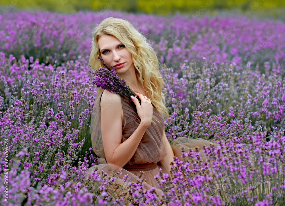 beautiful blonde girl in a light flying dress in a lavender field in summer enjoying her holidays beautiful blonde girl in a light flying dress in a lavender field in summer enjoying her holidays