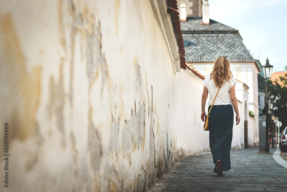 Woman wearing skirt is walking in ancient town Woman wearing skirt is walking in ancient town