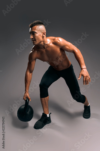 guy in black shorts leads active healthy lifestyle. body and health care, isolated gray background, studio shot.