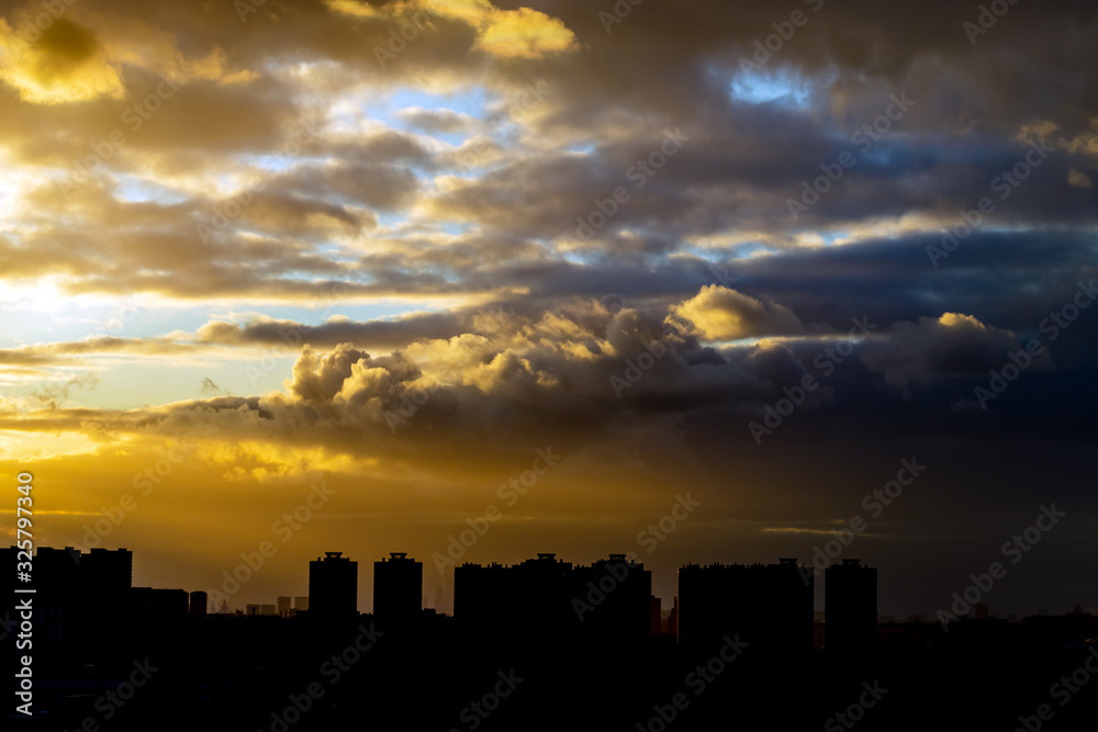 thunderclouds at sunset against the backdrop of urban development