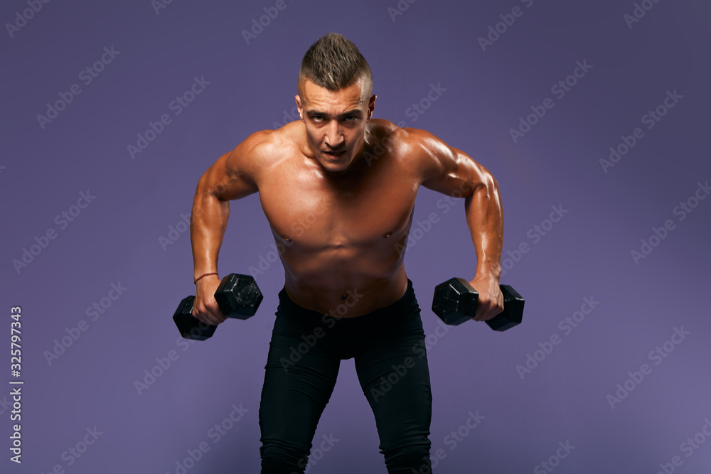 serious bodybuilder lifting heavy dumbbells, looking to camera, man working out at gym, keeping fit, close up portrait, isolated blue background, studio shot, weightlifting, effort, motivation serious bodybuilder lifting heavy dumbbells, looking to camera, man working out at gym, keeping fit, close up portrait, isolated blue background, studio shot, weightlifting, effort, motivation