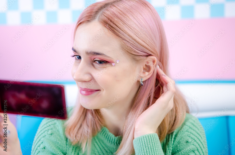 Fototapeta premium Young blonde woman with fresh healthy skin looking in mirror