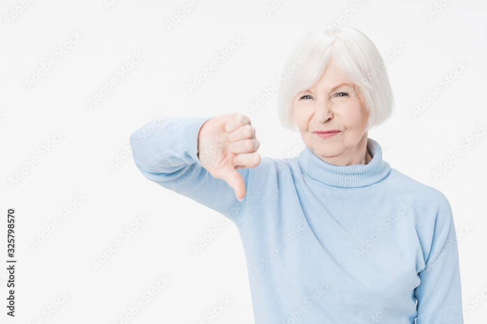 Old woman showing thumb down over white background Old woman showing thumb down over white background