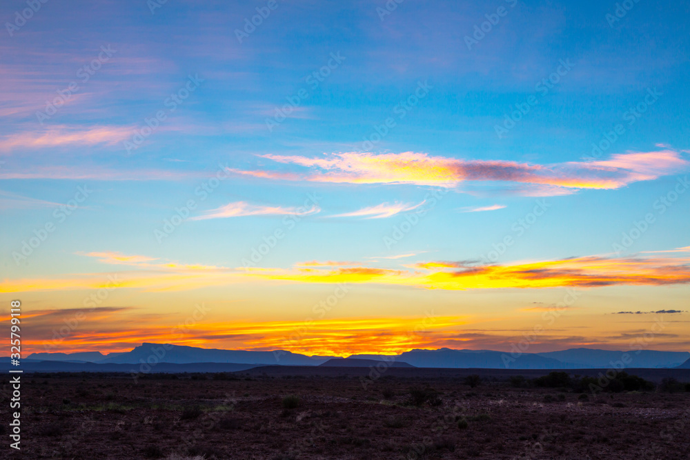 Yellow clouds and blue mountains at sunset in the Karoo
