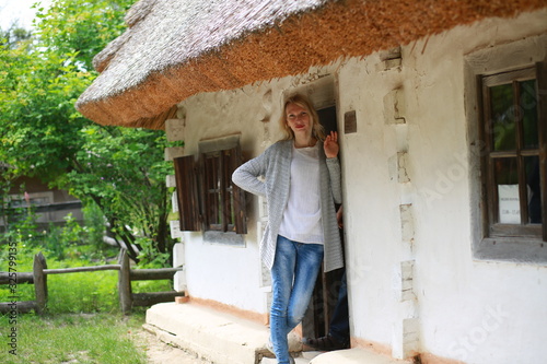  Blond girl with mini jeans resting on the porch of an old Ukrainian-style house © Alina
