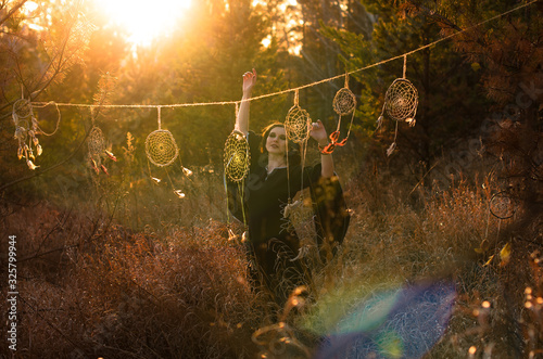 Boho style woman dancing near dreamcatchers. Female  freedom,  witch, gypsy style concept photo