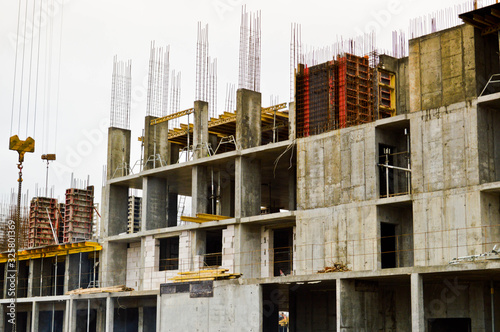 The process of construction and repair of a new modern cement concrete stone pannel monolithic frame-block building of a house with iron reinforcement at an industrial construction site photo