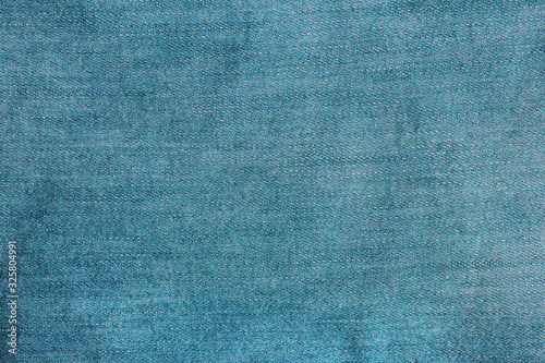 Jeans texture background of denim light blue color cloth pattern. Empty jean fabric surface, blank casual blue jeans clothing detail. Plain bright blue jeans blank wallpaper 