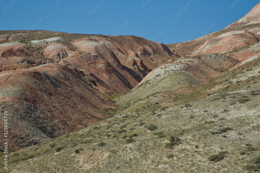 Red mountains in Xizi, Azerbaijan. Colorful hills . Сolorful geological formations . Red striped hills, rainbow mountains . View of the beautiful striped red mountain .