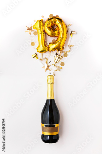 Happy 19th anniversary party. Champagne bottle with gold number balloon.