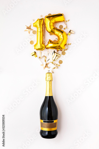 Happy 15th anniversary party. Champagne bottle with gold number balloon.