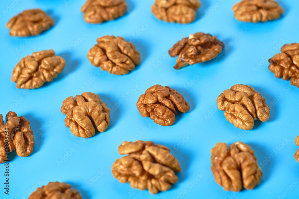 Scattered halves of pulp of walnut on blue background Scattered halves of pulp of walnut on blue background