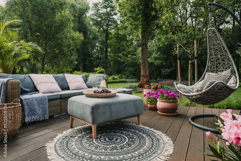 Garden patio decorated with Scandinavian wicker sofa and coffee table - obrazy, fototapety, plakaty 