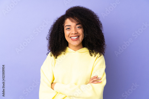 Young african american woman isolated on purple background keeping the arms crossed in frontal position