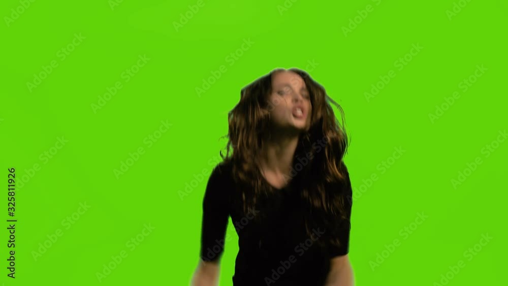 Young business woman on green chroma key background screaming angry, expression of madness and mental instability, madness concept