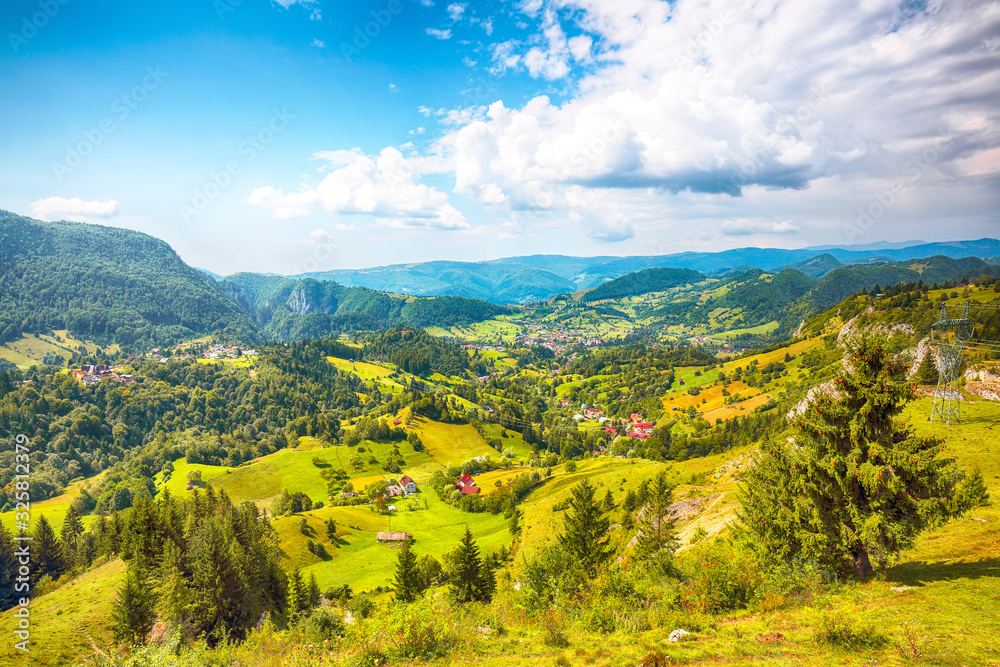 Naklejka premium Stunning alpine landscape with green fields and Piatra Craiului mountains in Dambovicioara Commune