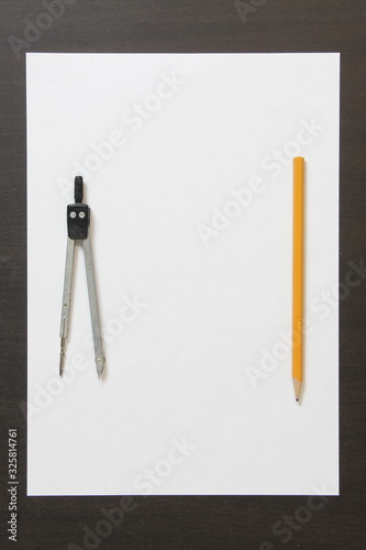 Template of white paper, divider and pencil on dark wenge color wooden background.