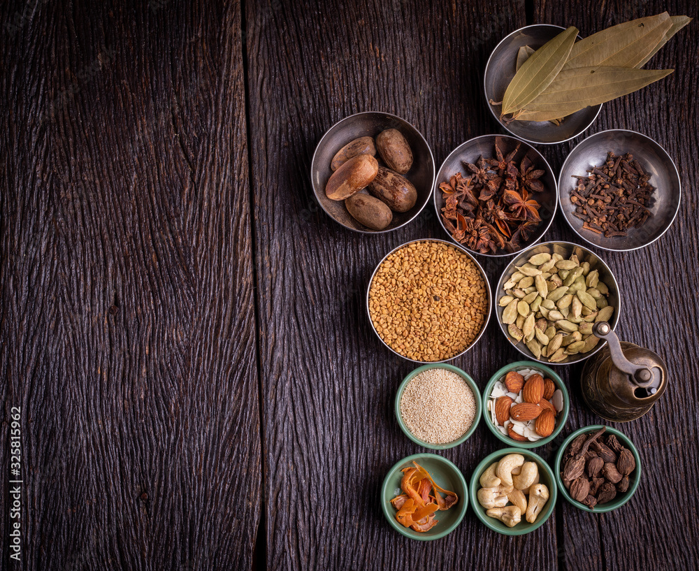 Set of various spices on rustic wood background. Pepper, turmelic, paprika, basil, rosemary, chilly, cardamom, cinnamon, anise. Top view with copy space.