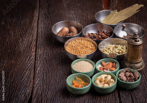 Set of various spices on rustic wood background. Pepper, turmelic, paprika, basil, rosemary, chilly, cardamom, cinnamon, anise. Top view with copy space. photo