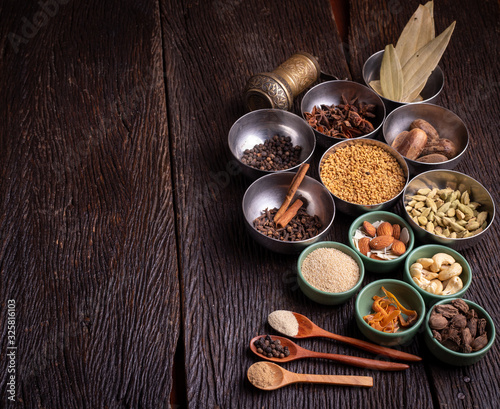 Set of various spices on rustic wood background. Pepper, turmelic, paprika, basil, rosemary, chilly, cardamom, cinnamon, anise. Top view with copy space.