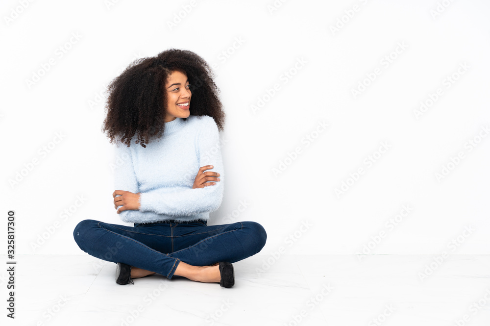 Young african american woman sitting on the floor happy and smiling Young african american woman sitting on the floor happy and smiling
