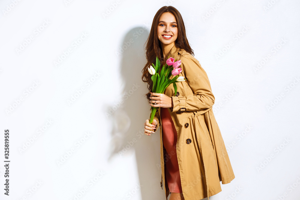 March 8 Fashion photo of a beautiful young woman with tulips in her hand. Spring concept. 