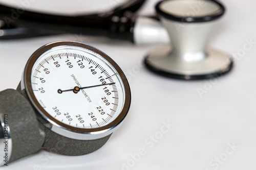 Closeup of blood pressure cuff gauge with high systolic reading of 170 mmHg. Stethoscope in background photo