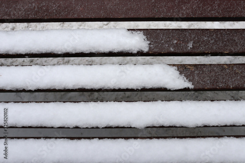 Benches and snow. Background of planks of benches and snow. Boards and snow. Snow texture on wooden planks
