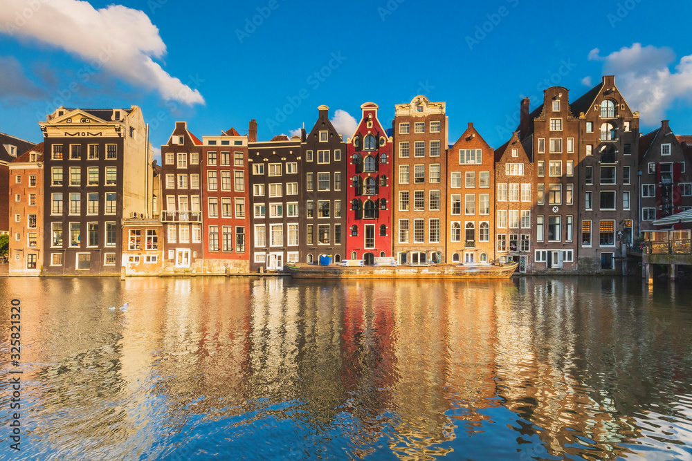 Typical houses reflecting in Damrak canal at sunset, Holland/Netherlands Typical houses reflecting in Damrak canal at sunset, Holland/Netherlands